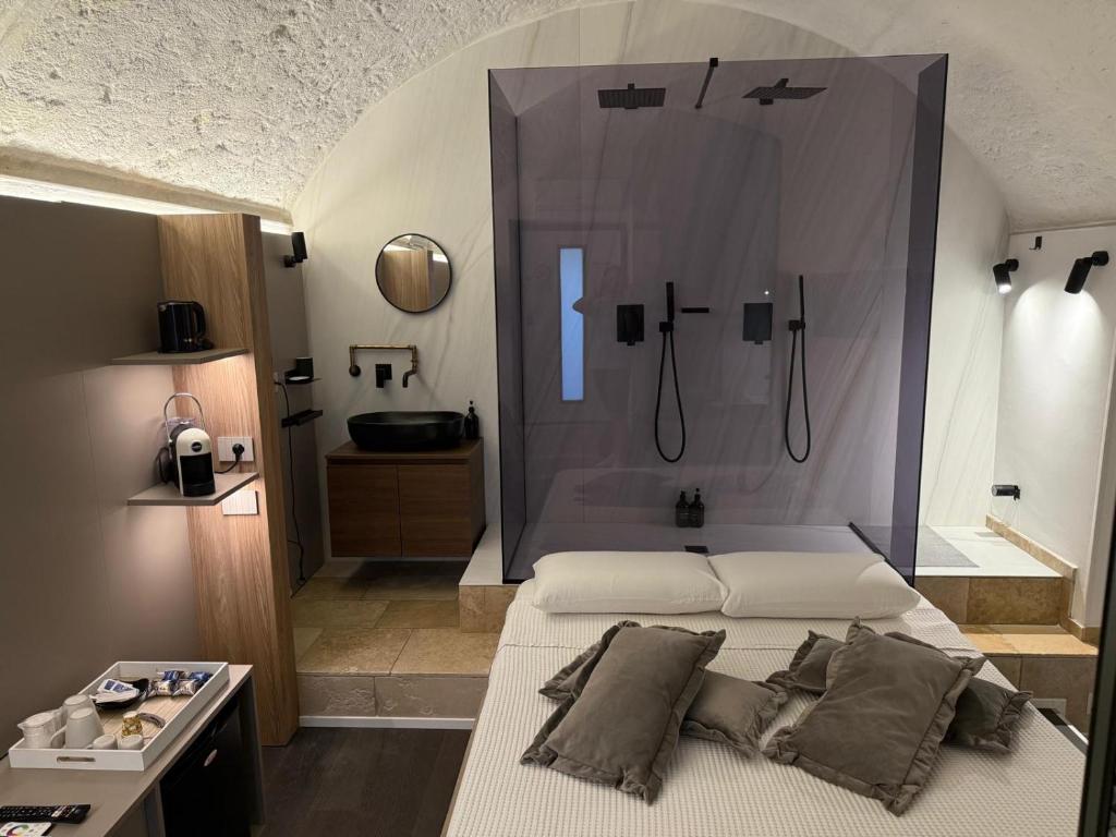 a bedroom with a shower and a bed with pillows at Lupariello Relais in Altamura