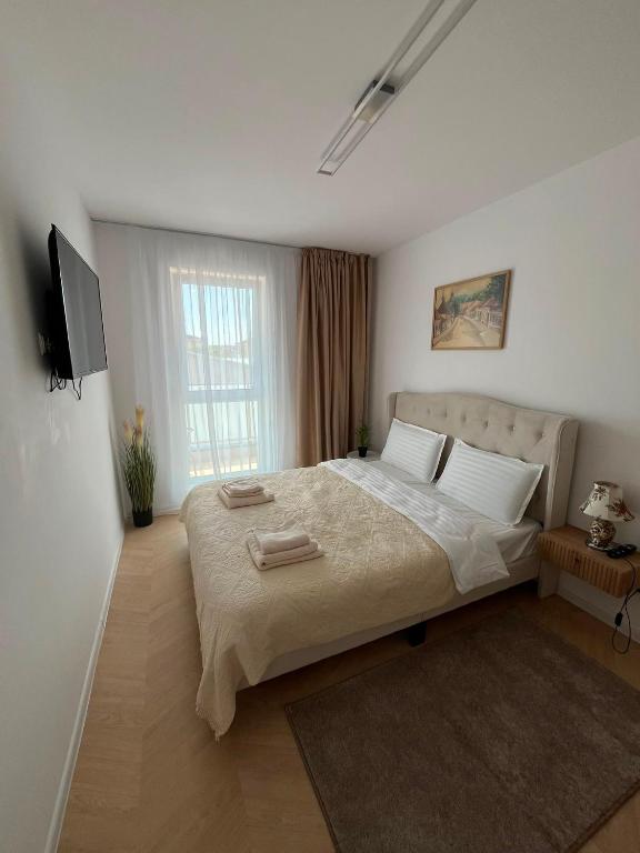 a bedroom with a large bed with two towels on it at Luna Residence in Baia Mare