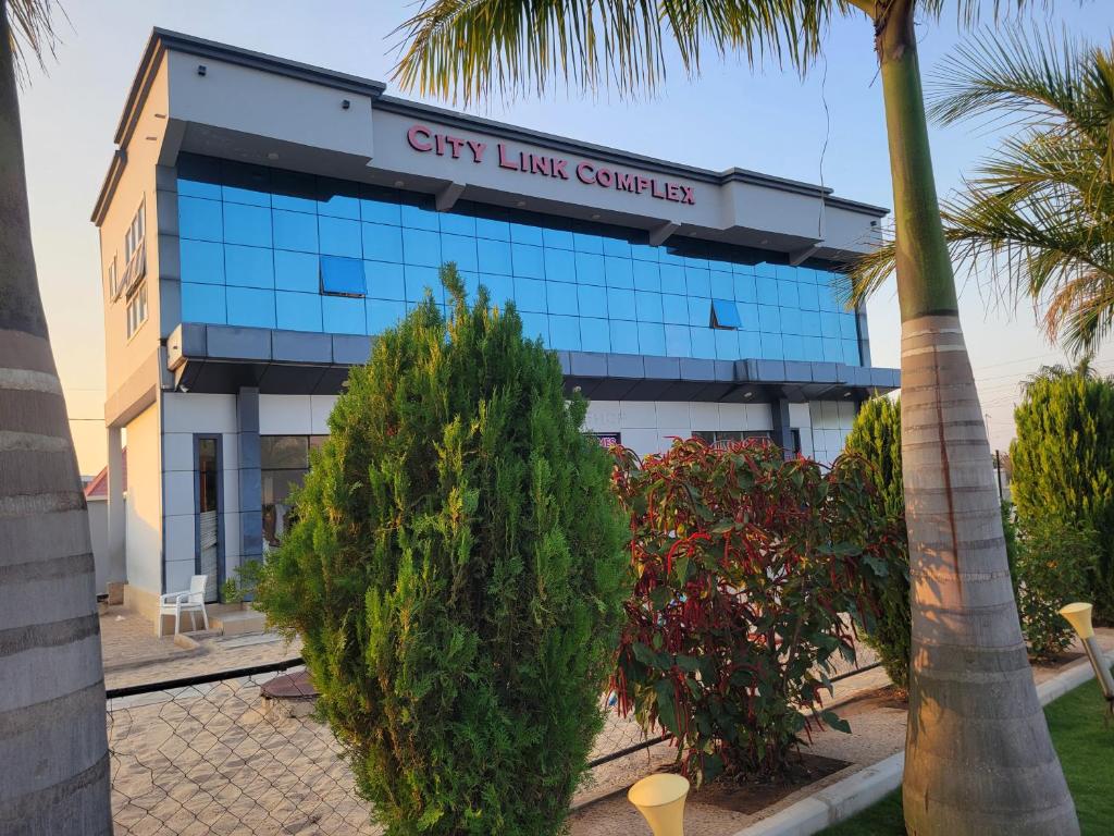 a building with a palm tree in front of it at City Link Complex Ressort in Mwanza