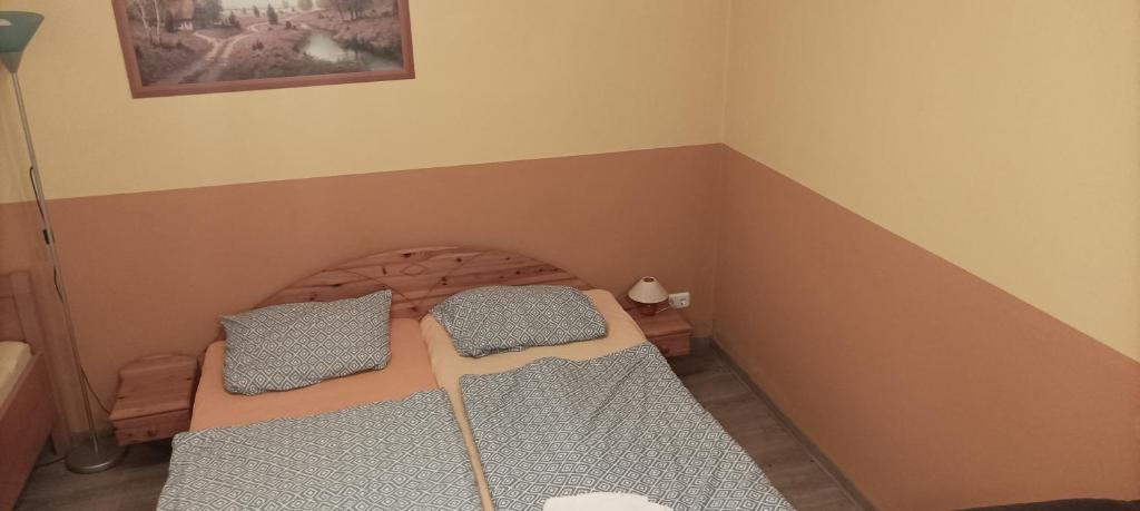 a small bedroom with a bed with two pillows at Pension Johnnys in Görlitz