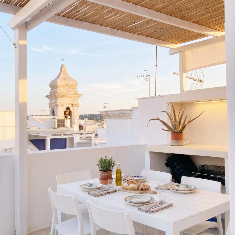 a white table and chairs on a balcony with a view at Casa con Vista a POLIGNANO a Mare in Polignano a Mare