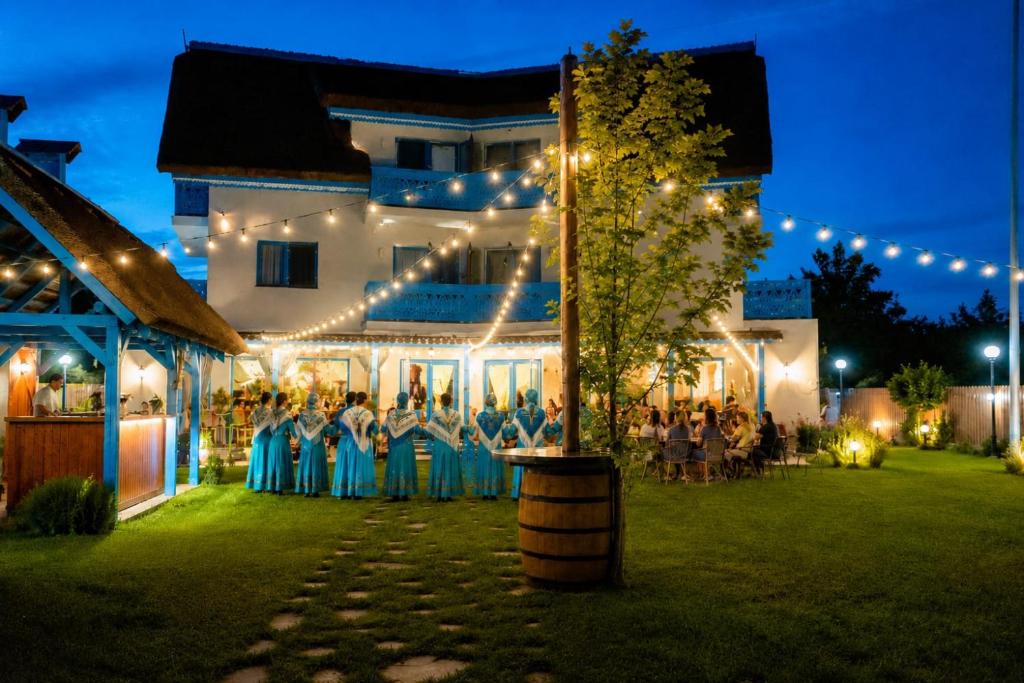 a wedding ceremony in front of a building with lights at Pensiunea Cuplu Călător in Jurilovca