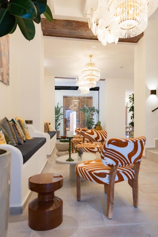 a living room with a chandelier and zebra chairs at Sant Blai Boutique Hotel - Javea in Jávea