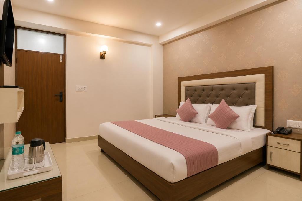 a bedroom with a large bed with pink pillows at Hotel Gold Ston Near Yashoda Hospital & Vaishali Metro in Ghaziabad