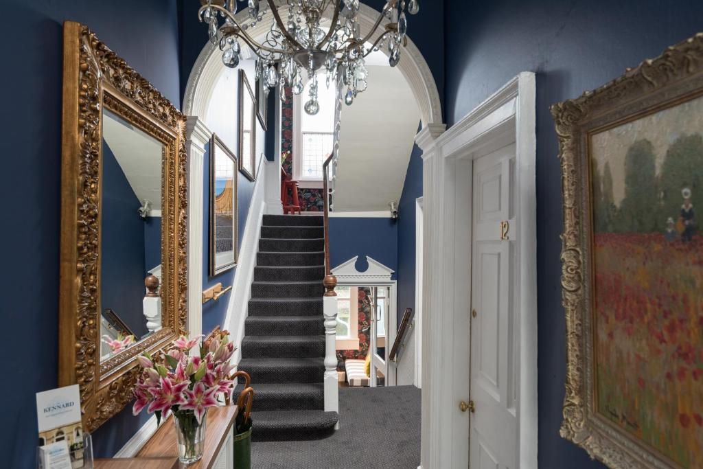 un couloir avec des murs bleus et un lustre dans l'établissement The Kennard Boutique Guesthouse, à Bath