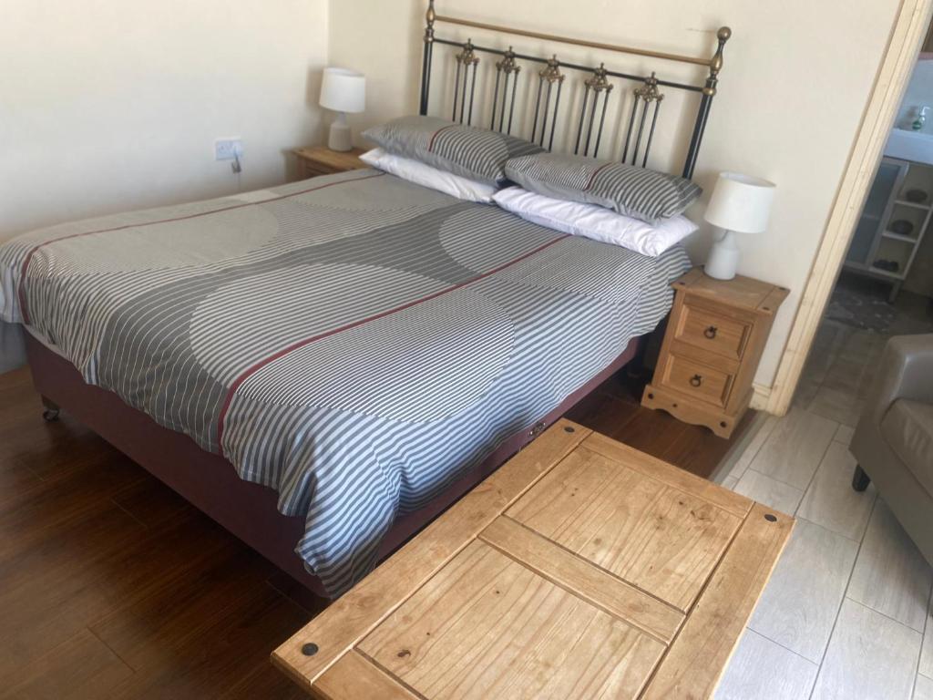 a bedroom with a bed and a wooden table at The Tackroom in Fanore