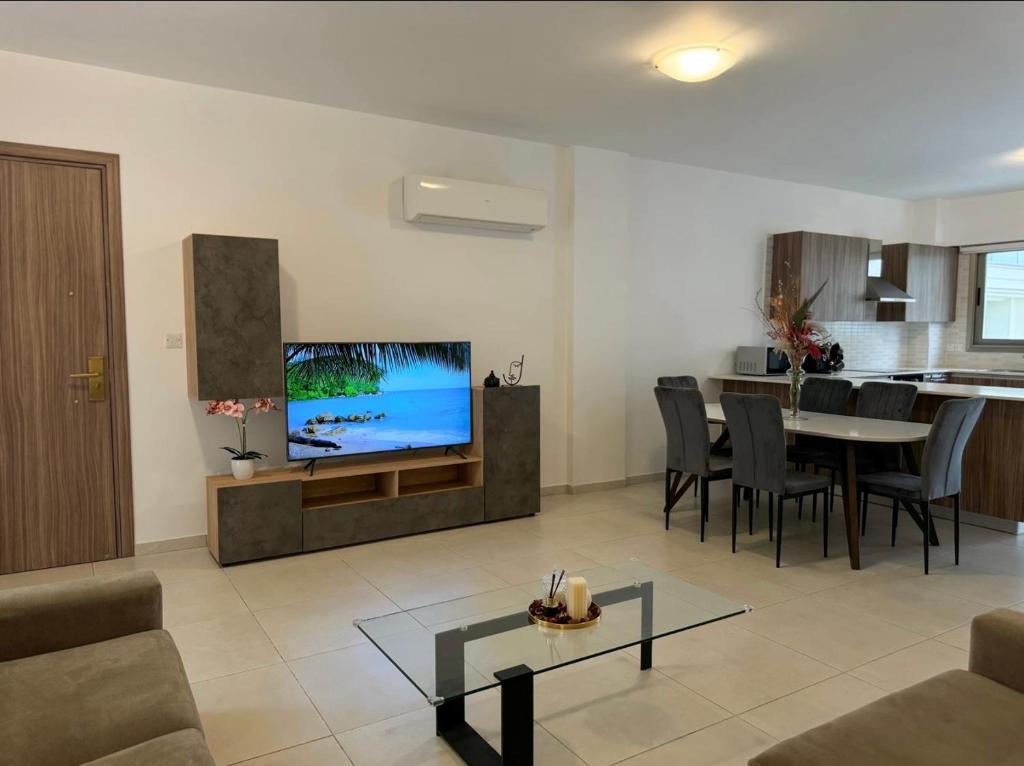 a living room with a television and a dining room at Halcyon Central Apartments in Larnaca