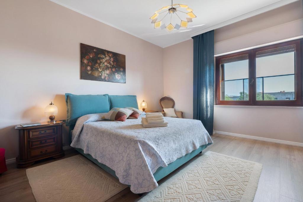 a bedroom with a bed with a blue blanket and a window at Casa Lele in Sarroch