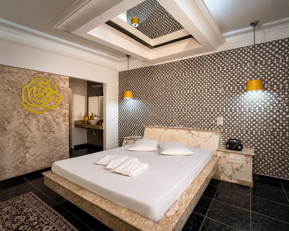 a bedroom with a large white bed with two pillows at Motel Marajas Mococa - Apartamento 03 in Mococa