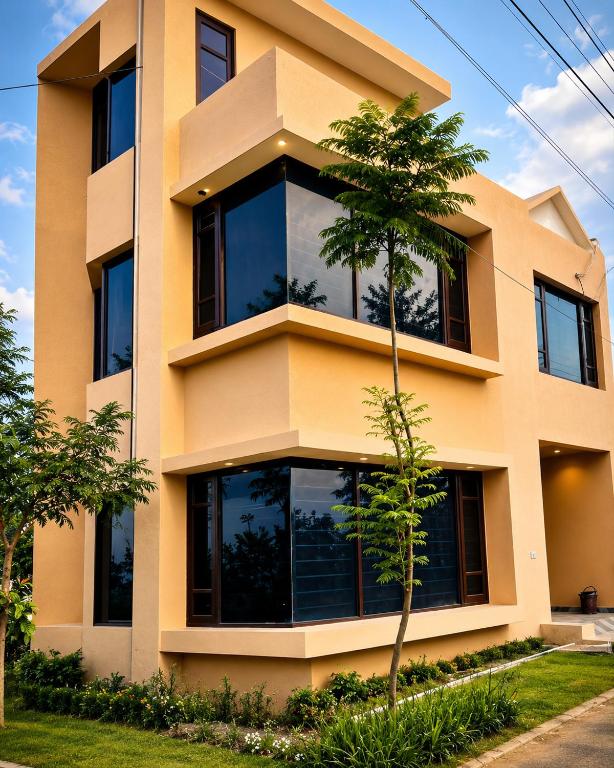 a yellow building with a tree in front of it at The Nawab's Villa in Mānakpur