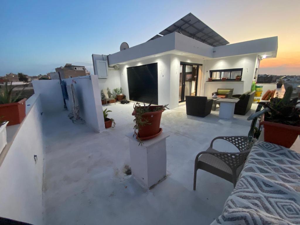 a white house with a tv on a roof at Bouchareb résidences in Quşaybat al Madyūnī