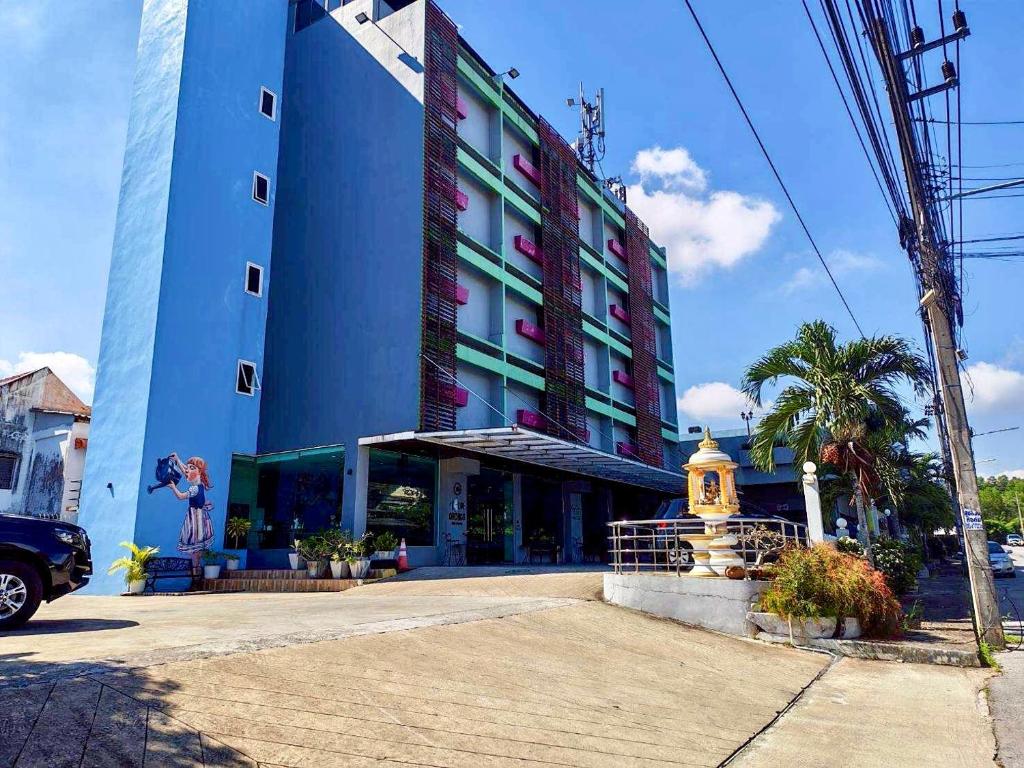 a large blue building with a fountain in front of it at Blue Orchids Hotel in Hat Yai