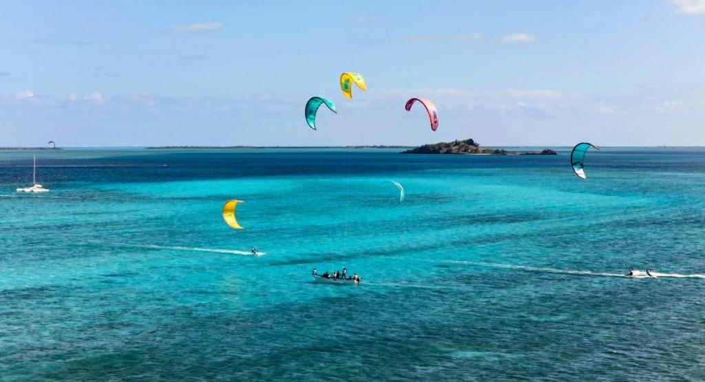 a group of people flying kites in the water at EcoDream Lodge in Port Mathurin