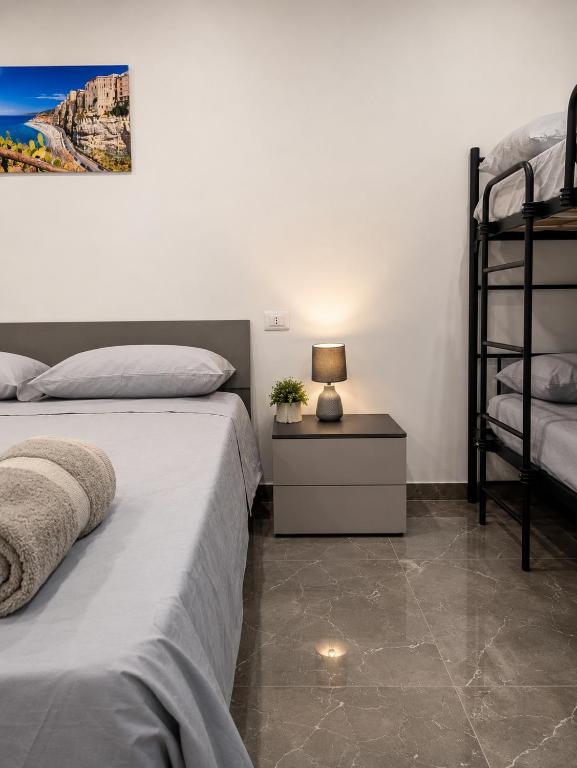 a bedroom with two beds and a lamp on a night stand at I Due Moli 2'0 Vibo Marina in Vibo Valentia Marina