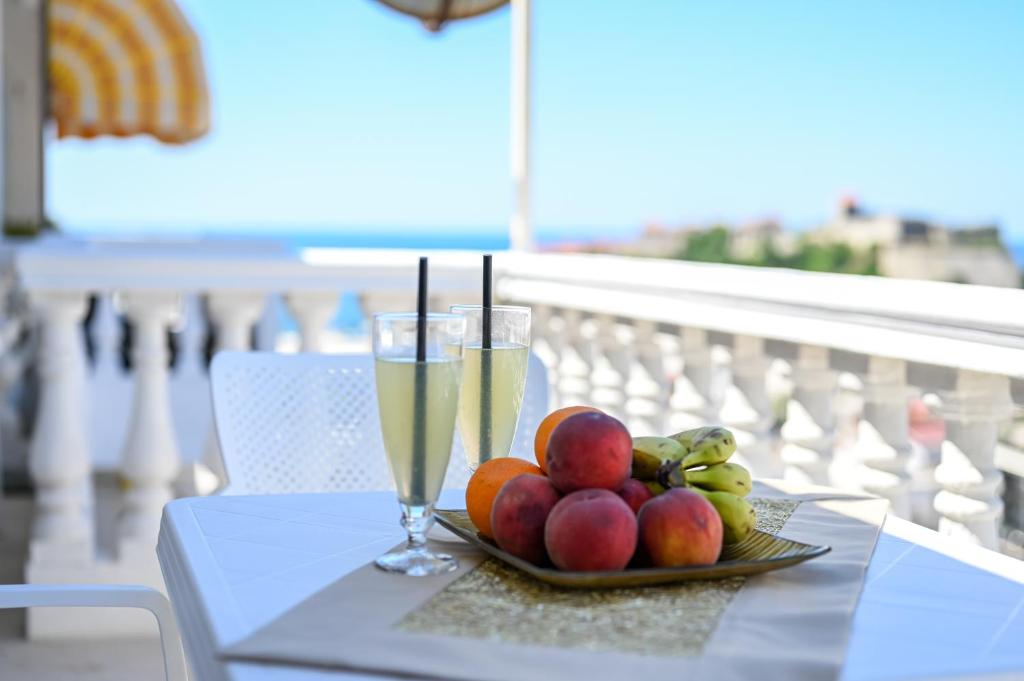 a plate of fruit and a glass of champagne on a table at Guesthouse Elsa in Ulcinj