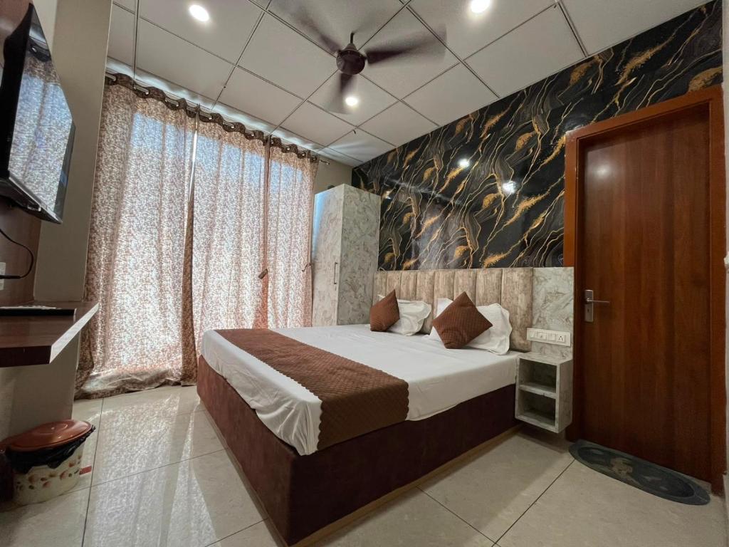 a bedroom with a bed and a ceiling fan at Hotel Dreamland in Hisār
