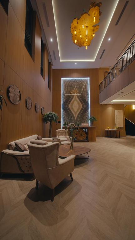 a lobby with a couch and chairs and a chandelier at August Suites & Chalets in Khŭjakent Bekati