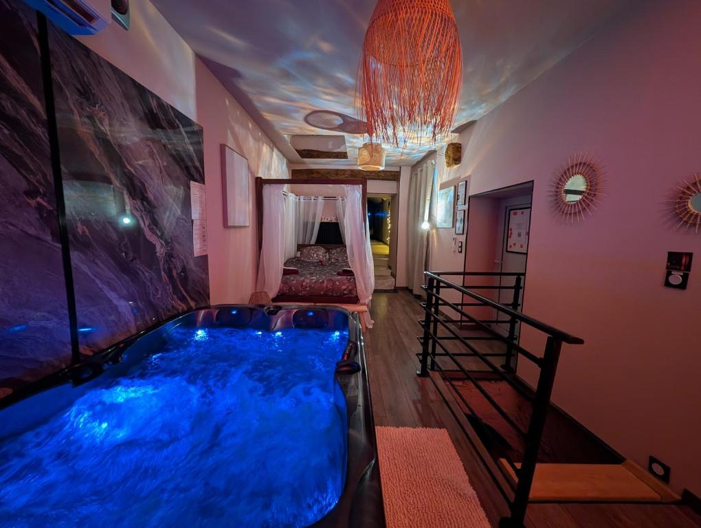 a large blue tub in a room with a bed at Loveroom Romantique avec Spa et Secret Room - A proximité des Lacs - La Mure in La Mure
