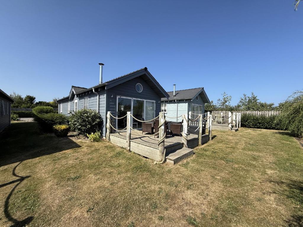 a blue house with a fence in a yard at Blue Anchor Retreat, The Bay, two bedrooms with ensuites, parking for 2 cars, 2 dogs welcome in Filey