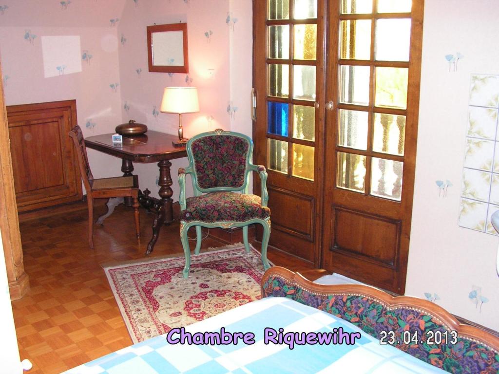 a living room with a chair and a table at Le Sonnenglanz in Beblenheim
