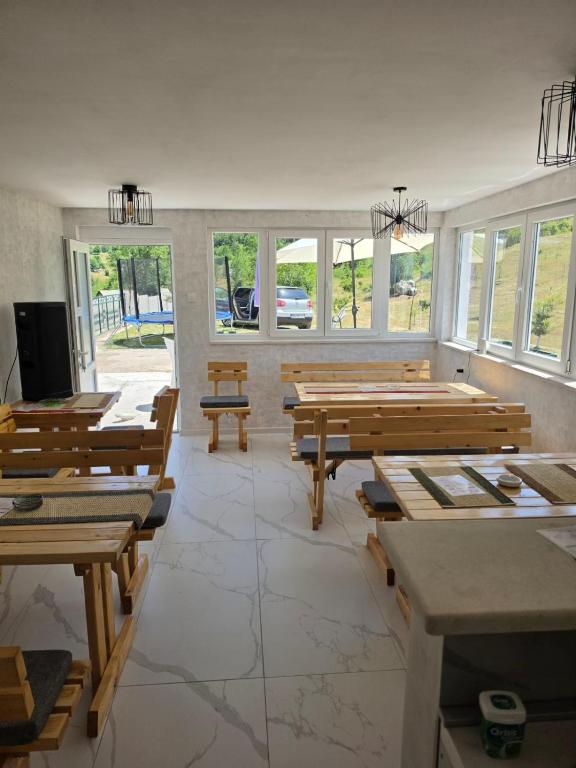 a large room with wooden benches and windows at Jezerina in Šavnik