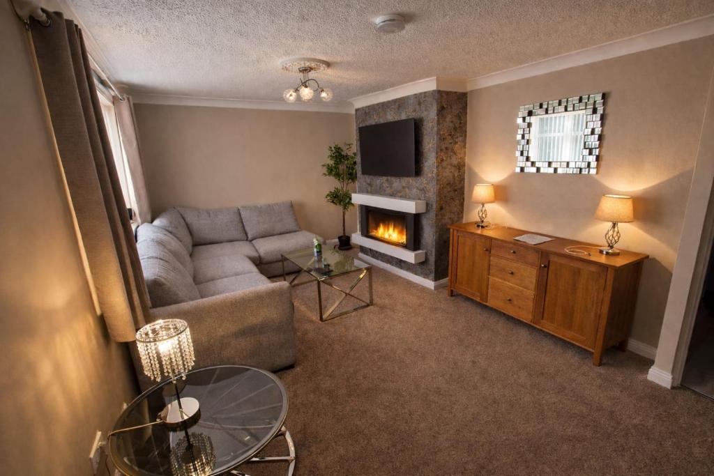 a living room with a couch and a fireplace at Cloverdale in Bedlington
