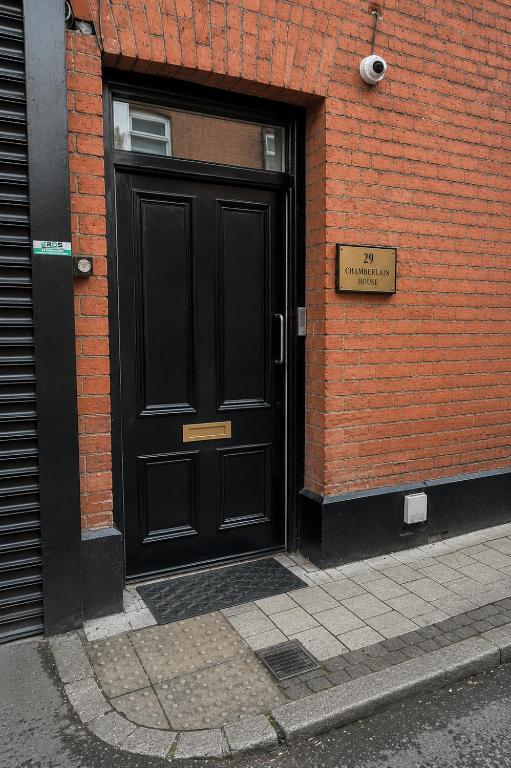 a black door on the side of a brick building at Chamberlain House in Derry Londonderry