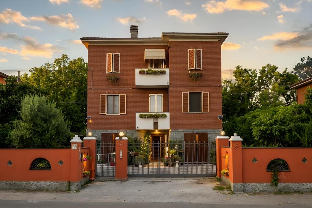 a red brick house with an orange fence at B&B Villa Firefly in Modena