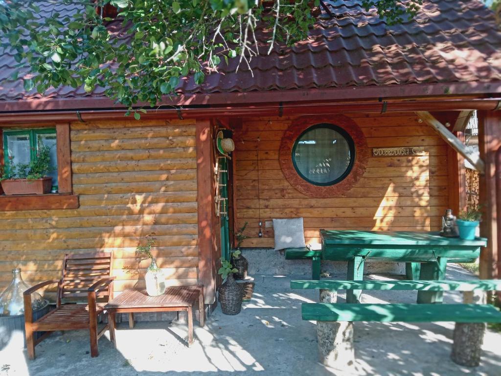 a wooden cabin with a picnic table and chairs at Kuća za odmor Urša in Brod na Kupi