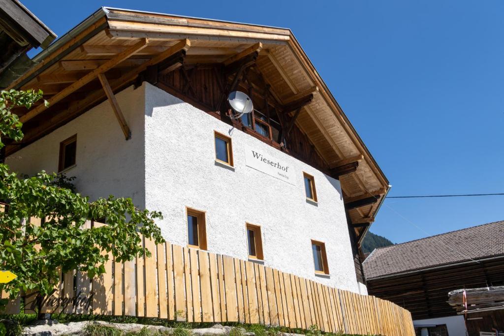 a large white building with a wooden fence at Wieserhof Sellrain in Sellrain