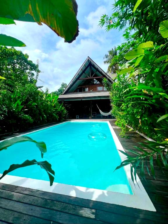 a swimming pool in front of a house at Tropical Jungle Villa 5 min walk to Cloud 9 in General Luna