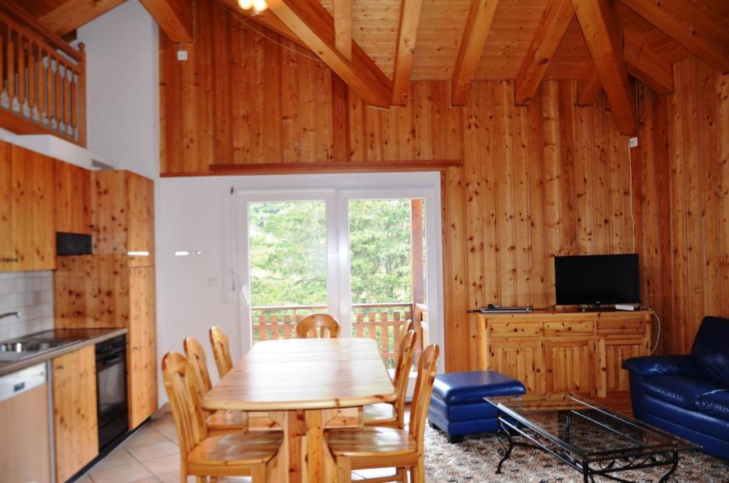 a kitchen and dining room with a wooden table and chairs at Immeuble La Foret in Vex