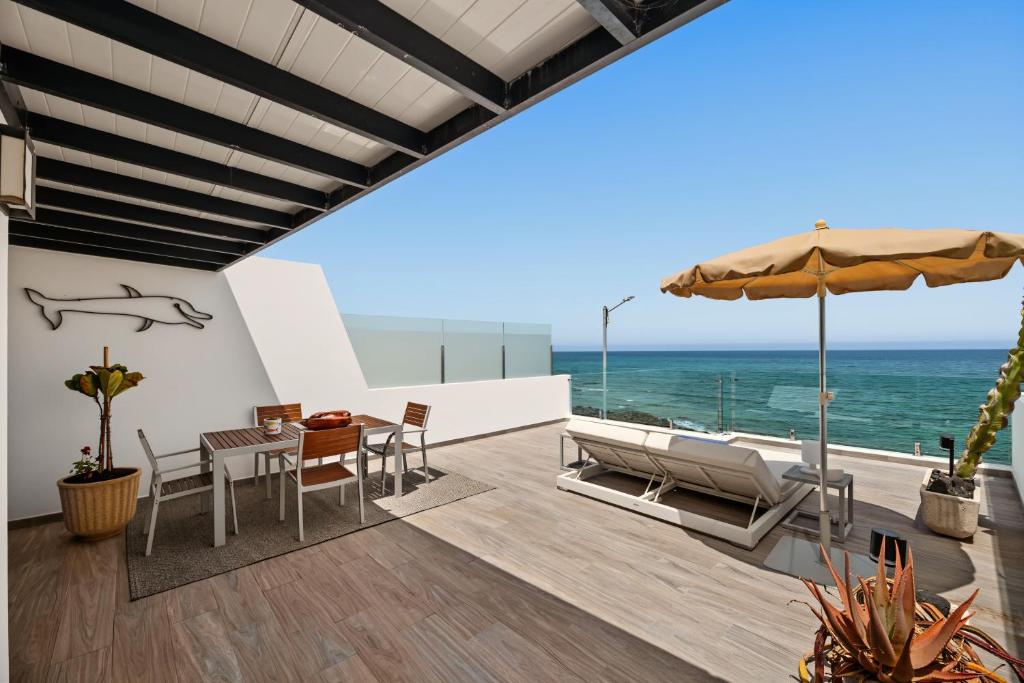 a patio with a table and chairs and the ocean at Callao Beach 6 in Arrieta