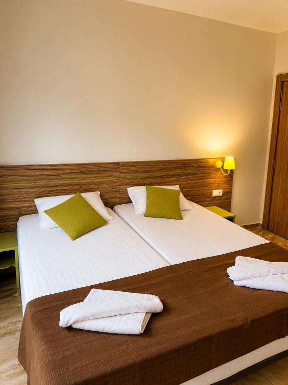 a bedroom with two beds with green pillows at Deluxe Suites ALL Inclusive in Sunny Beach
