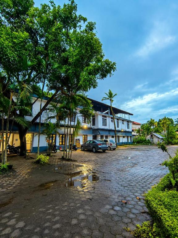 a group of buildings with cars parked in a parking lot at PRATHIBA RESIDENCY in Kollam