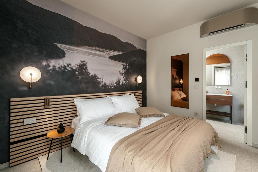 a bedroom with a large bed and a painting on the wall at Fančita Rooms B&B in Vrsar