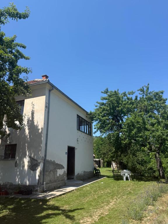 a white building with a door in a yard at Kod Marijanovića in Andrijevica