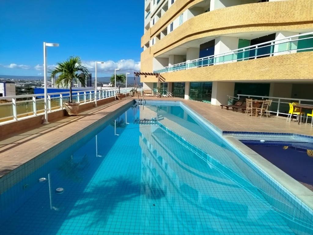 a large swimming pool next to a building at Studio 404 Premium Flat - Juazeiro do Norte - Cariri in Juazeiro do Norte