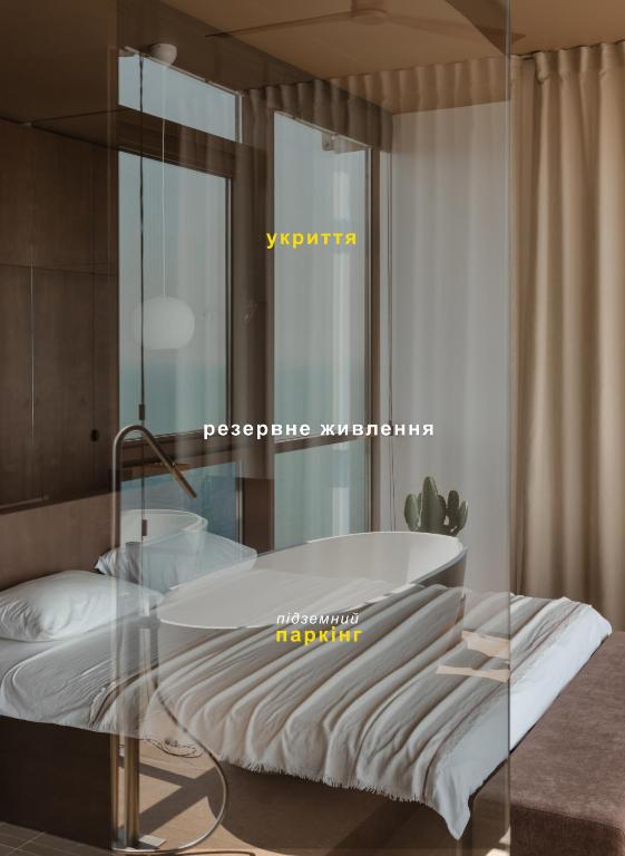 a bedroom with a bed with a glass wall at Sea and Sky Apartment in Odesa