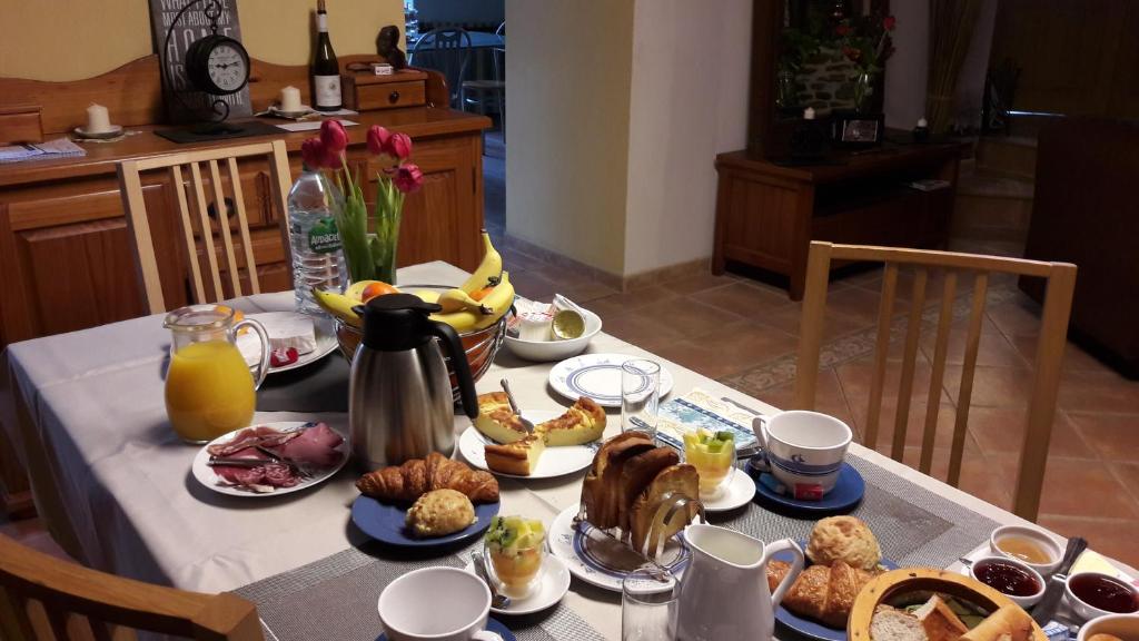 a table topped with breakfast foods and orange juice at La Grande Mare in Saint-Benoît-des-Ondes