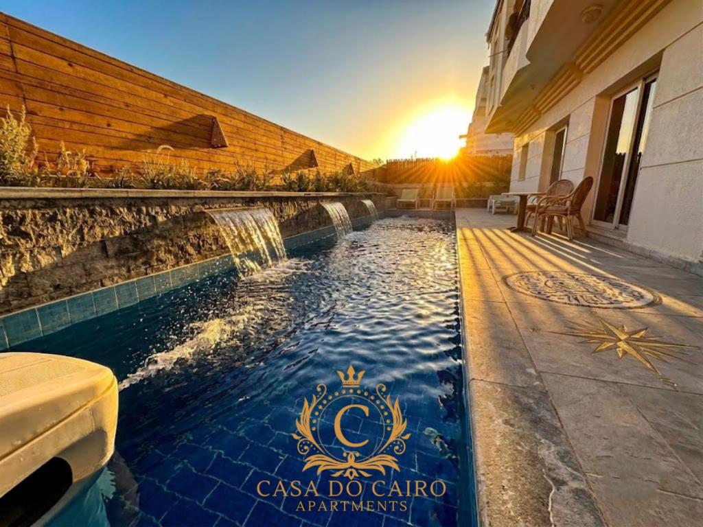 a pool with a sign on the side of a building with the sunset at Casa Do Cairo-Sharm Alsheikh in Sharm El Sheikh