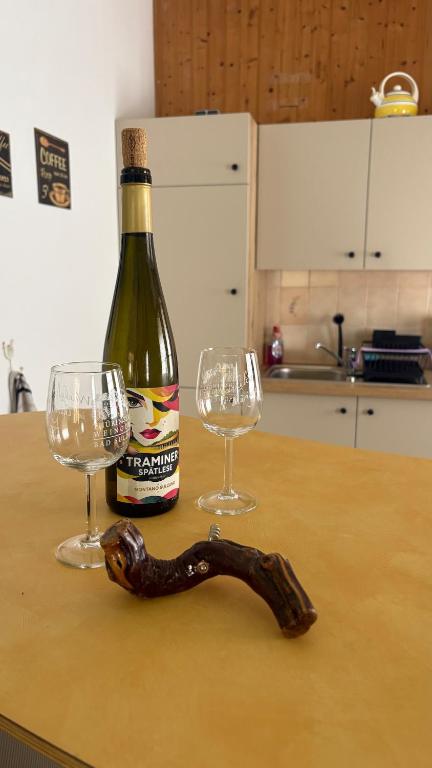 a bottle of wine and two glasses on a table at Moderne offene Wohnung in Bad Sulza