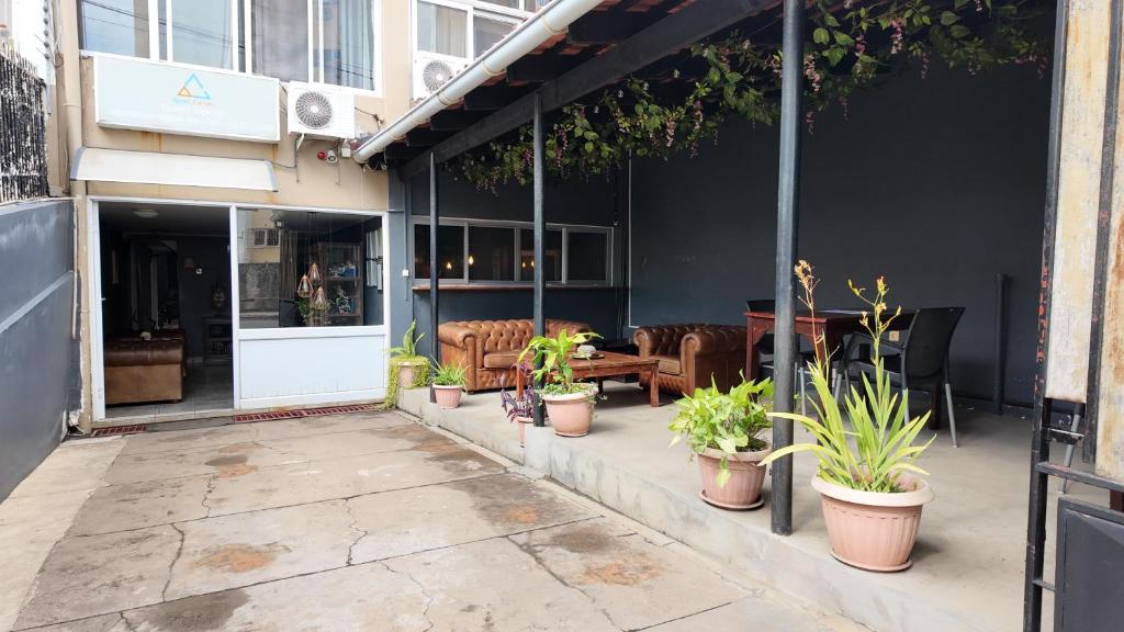 an outdoor patio with potted plants in front of a building at The Quiet Corner Guest House in Maputo