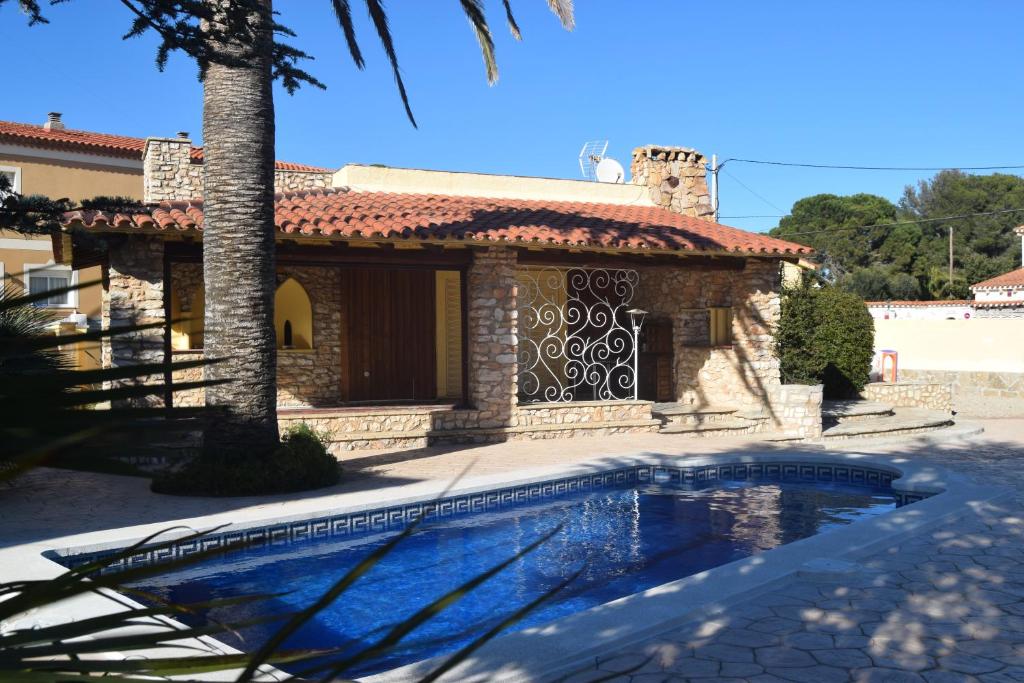 a house with a swimming pool in front of a house at Villa la Masia in Miami Platja