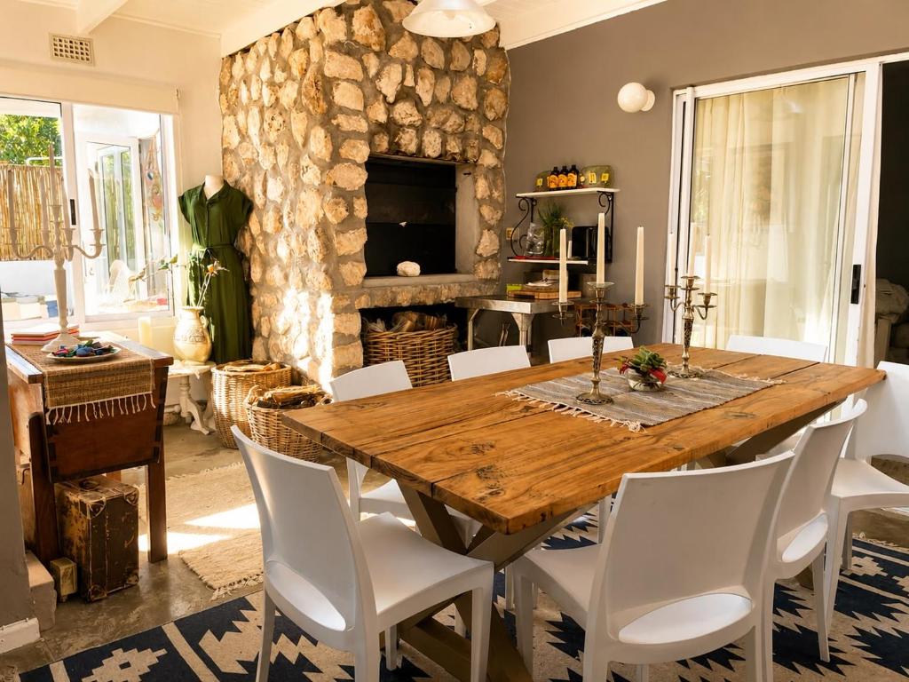 a dining room with a wooden table and a fireplace at Tanzanite in Paternoster