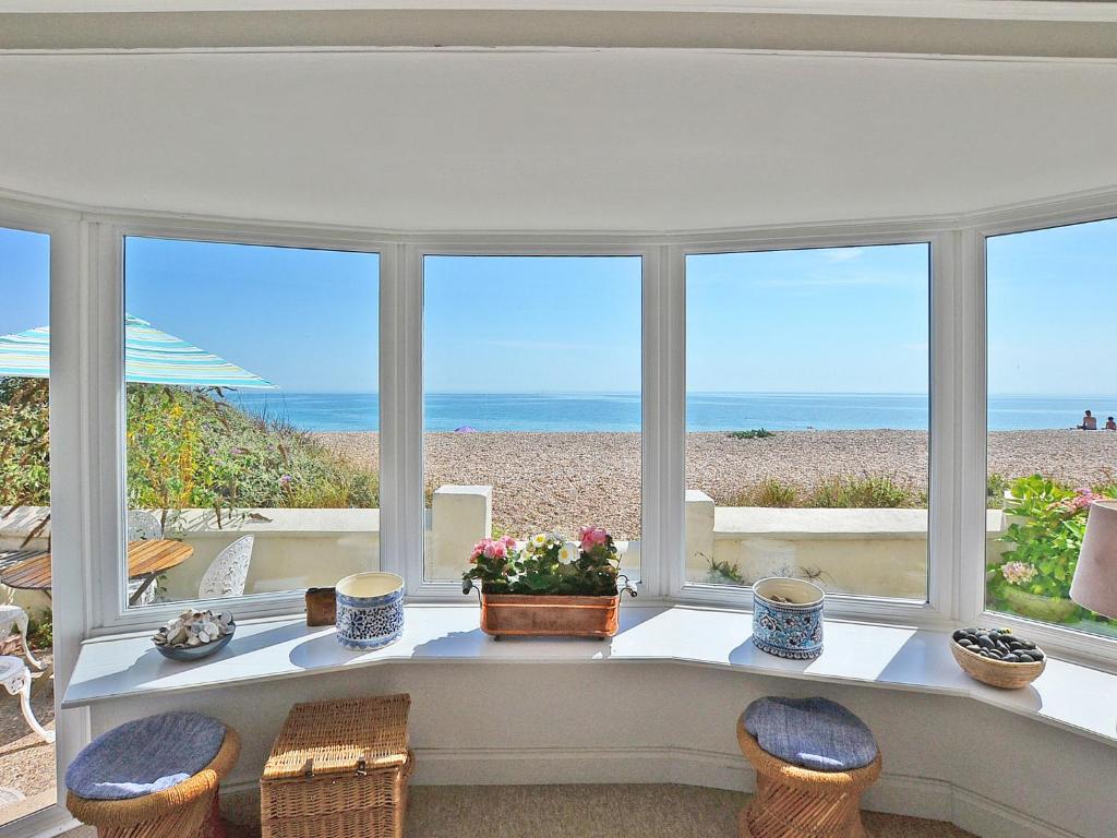 a room with a table with a view of the beach at Thalassa in Pagham