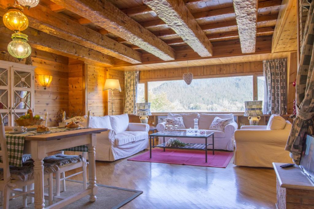 a living room with white furniture and a large window at Pescasseroli Appartamento Panoramico in Pescasseroli