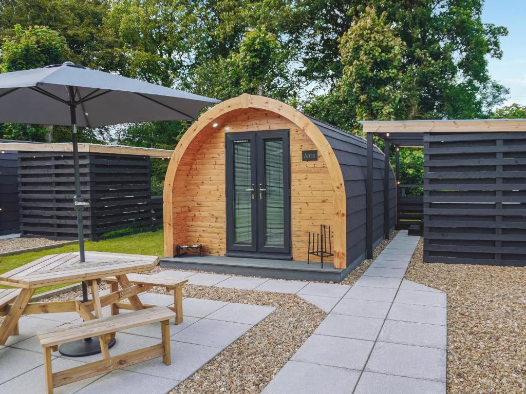 a small wooden hut with a table and an umbrella at Arran - Uk48415 in Dalry