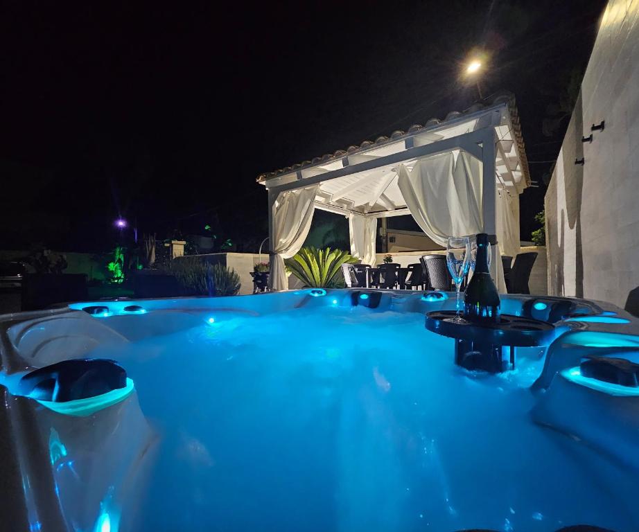a blue bath tub with a gazebo at night at Villa Anny in Avola