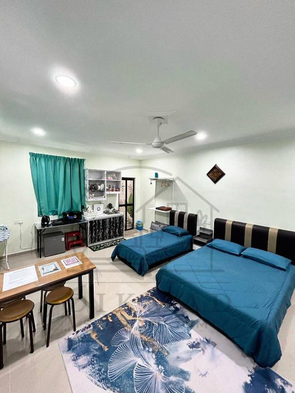 a living room with two beds and a table at Dikmad Studio Room Bukit Mentok, Kemaman in Cukai